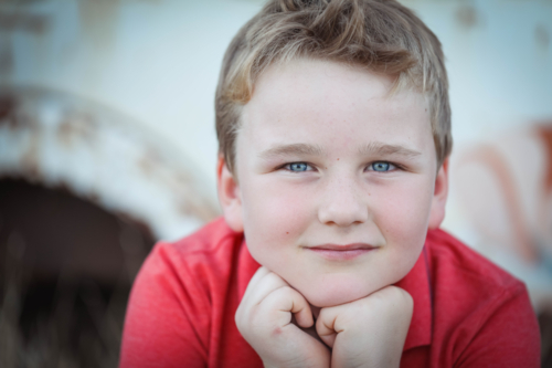 Close up portrait of young Caucasian boy with blue eyes - Australian Stock Image