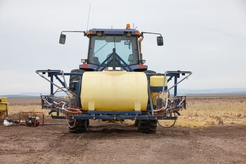 close up shot of a yellow tractor in an empty field - Australian Stock Image