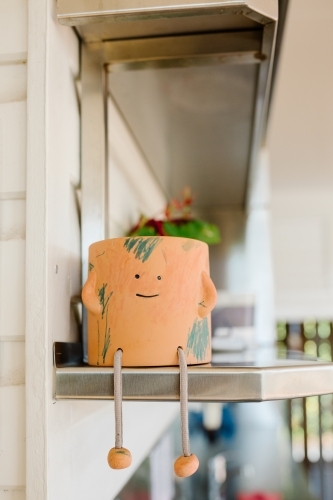 Close up shot of an orange pot with a smiling face - Australian Stock Image