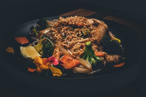 Close up shot of pad thai chicken in black plate - Australian Stock Image