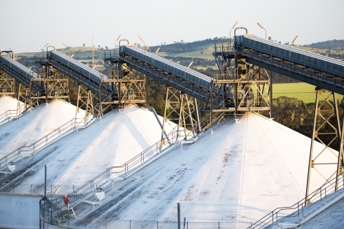 Close up shot of tall grey industrial steels and white roof of warehouse and factory in a rural area - Australian Stock Image