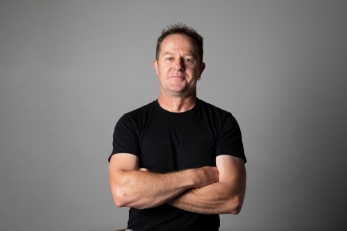 Close -up, waist high, portrait of a man with arms folded. - Australian Stock Image