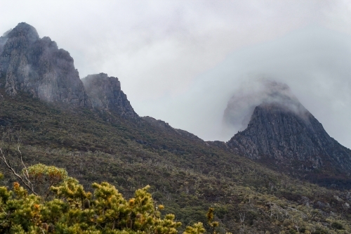 Cloud over steep mountain peaks, Cradle Mountain - Australian Stock Image