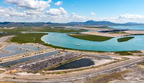 Coal sedimentation ponds, with Mount Larcom in the background, Gladstone, Queensland - Australian Stock Image