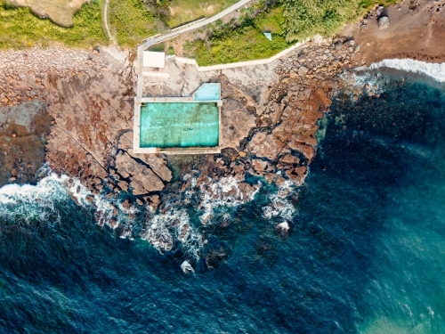 Coalcliff sits on a cracking crumbling rockshelf and its pools are fed by the ocean tides - Australian Stock Image