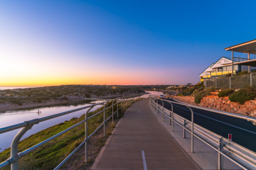 Coastal Drive in Port Noarlunga with shared footpath and bike track along the Onkaparinga River - Australian Stock Image