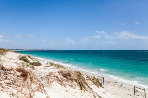 Coastal scene of sand dunes and beach with clear water in the sunlight - Australian Stock Image