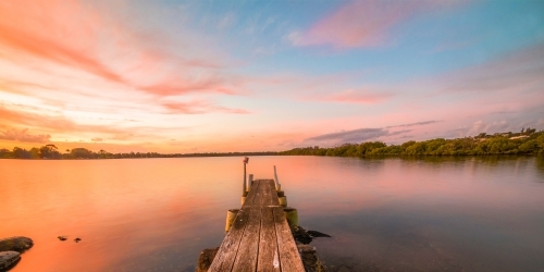 Coloured sky looking toward the river with the pier in the foreground - Australian Stock Image