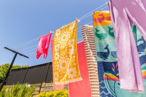 Colourful towels and swimmers hanging on washing line - Australian Stock Image