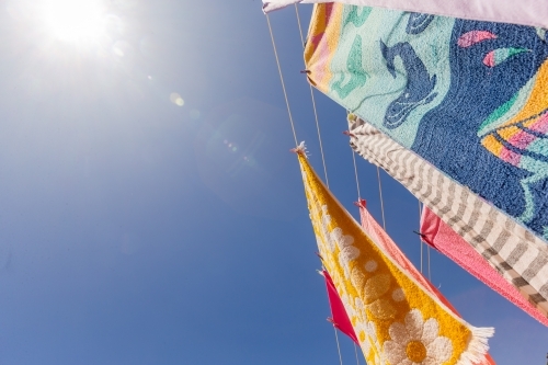 Colourful towels and swimmers hanging on washing line - Australian Stock Image