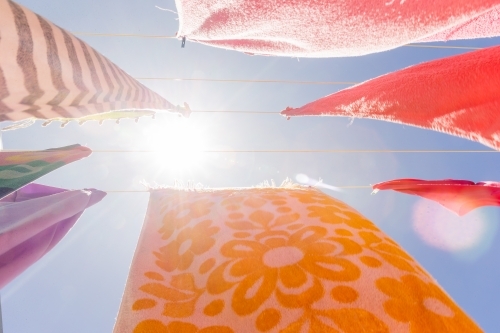 Colourful towels and swimmers hanging on washing line - Australian Stock Image