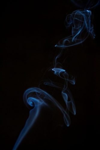 Column of fine smoke in darkness - Australian Stock Image