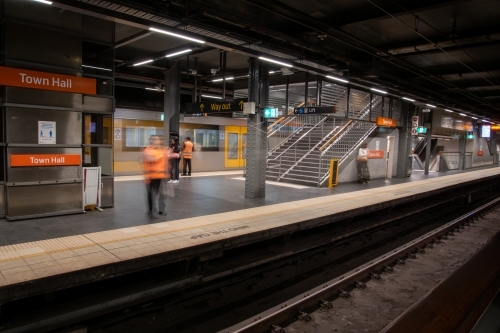 Commuters and staff on station platform with blurred motion - Australian Stock Image