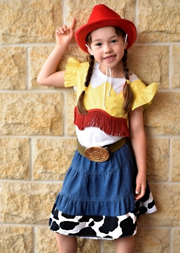 Concert Rehearsal young girl in a fancy costume posing against a brick wall - Australian Stock Image