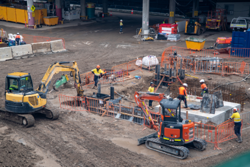 Construction site with machinery and workers in high-vis - Australian Stock Image