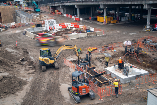 Construction site with machinery and workers in high-vis - Australian Stock Image