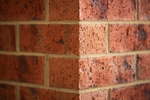 Corner of a red brick building, one light side and one dark side - Australian Stock Image