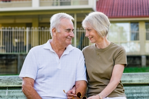 couple sitting on park bench, - Australian Stock Image