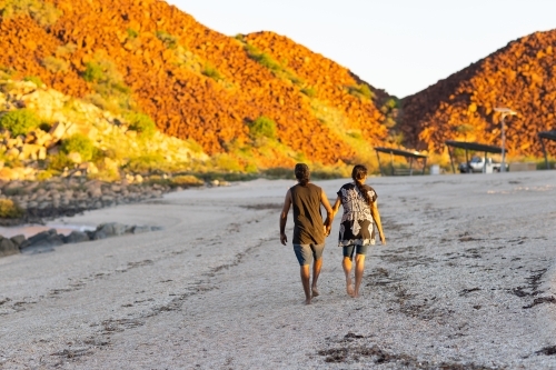 couple walking away along the beach in the Pilbara - Australian Stock Image