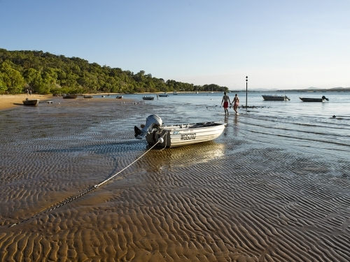 Couple walking on beach at low tide - Australian Stock Image