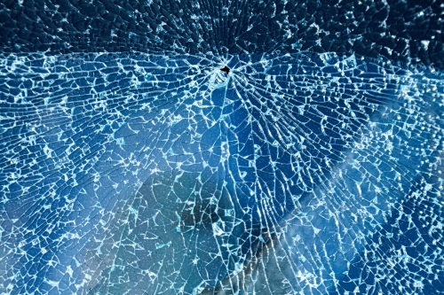 Cracks in glass of shattered car window - Australian Stock Image