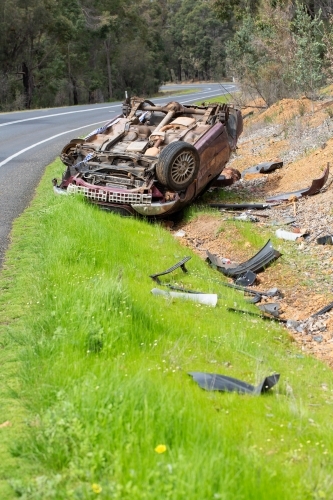 Crashed vehicle upside down on side of highway - Australian Stock Image