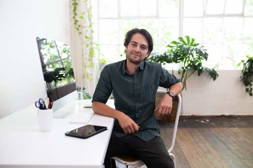 Creative business man looking at camera in studio environment - Australian Stock Image