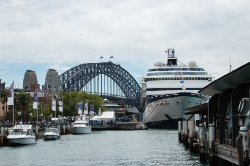 Cruise ship docked in Sydney Harbour with bridge behind - Australian Stock Image