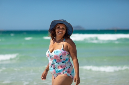 curvy dark-skinned lady in swimsuit at the beach - Australian Stock Image