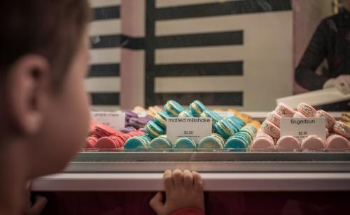 Cute 4 year old mixed race boy chooses a macaron treat - Australian Stock Image