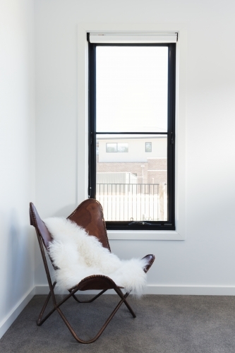 Cute leather chair with sheepskin rug throw - Australian Stock Image