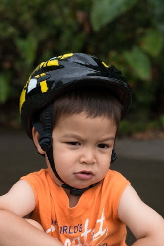 Cute mixed race 4 year old boy gets up after falling off his bike - Australian Stock Image