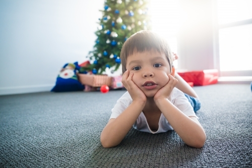 Cute mixed race 4 year old boy waiting for Christmas - Australian Stock Image