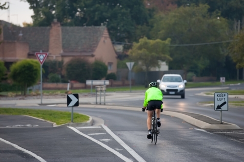 Cyclist approaching a roundabout in the evening - Australian Stock Image