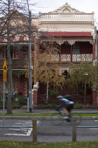 cyclist riding down a street in inner city suburbs - Australian Stock Image