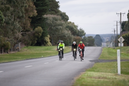 Cyclists riding in the middle of a country road - Australian Stock Image