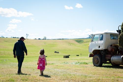 Dad & little girl walking in a hay paddock