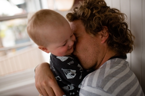 Daddy cuddles baby - Australian Stock Image