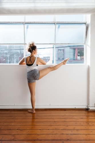 Dance instructor stretching before taking a class - Australian Stock Image