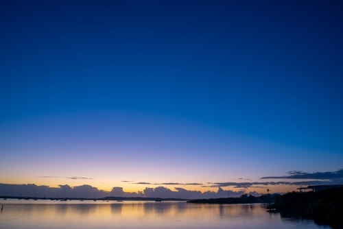 Dawn sky over water with clouds - Australian Stock Image