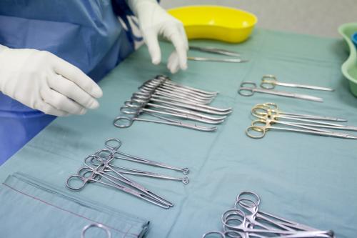 Detail of a theatre nurse preparing equipment for surgery in a hospital operating theatre - Australian Stock Image