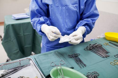 Detail of a theatre nurse preparing equipment for surgery in a hospital operating theatre