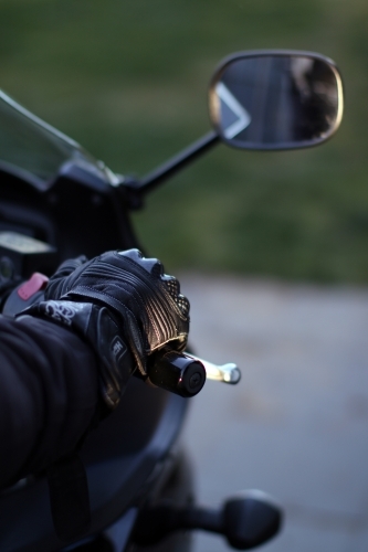 Detail of motorbike glove holding handlebar - Australian Stock Image