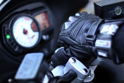 Detail of motorbike glove holding handlebar - Australian Stock Image