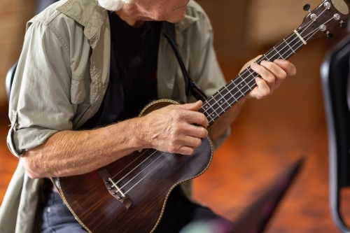 detail of older man playing a ukulele - Australian Stock Image