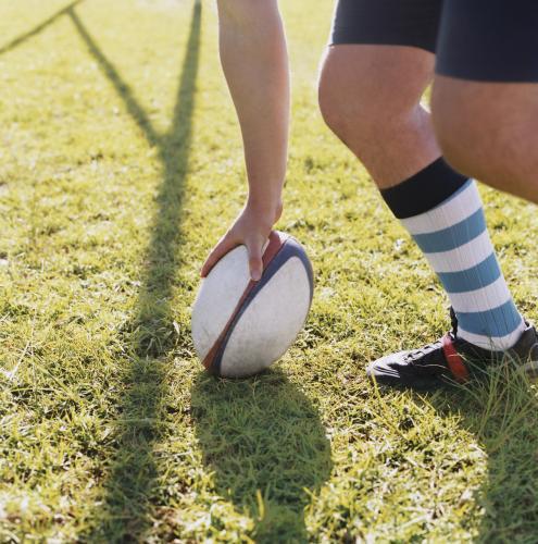 Detail of person placing a rugby union ball on the ground