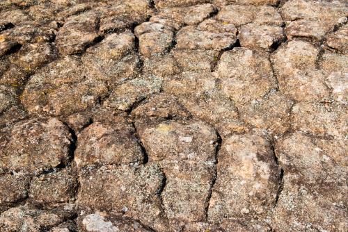 Detail shot of heavily textured and patterned rock with cracks - Australian Stock Image