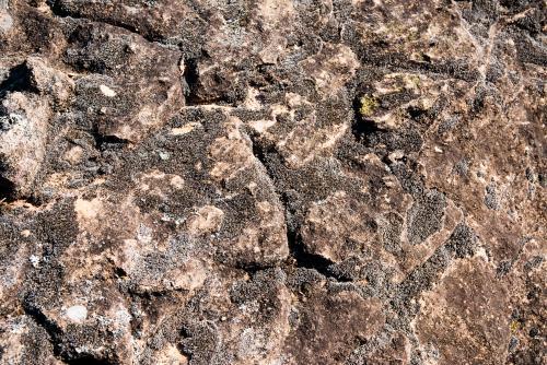 Detail shot of heavily textured and patterned rock with cracks - Australian Stock Image