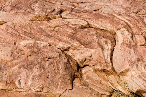 Detail shot of pink and orange rock with texture, patterns and cracks - Australian Stock Image