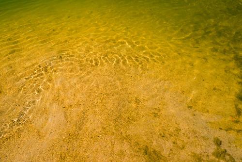 Detail shot of water with ripples and green and yellow tones - Australian Stock Image